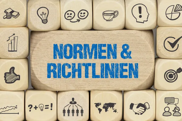 Mehrere Würfel übereinander, mit der Aufschrift: Normen und Richtlinien 
